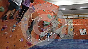 Children are engaged in extreme sports on the indoor climbing wall.