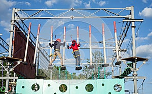 Children enjoying activity in a climbing adventure park on a sunny day.