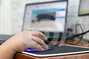 Children enjoying computer games while holding computer mouse