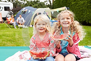 Children Enjoying Picnic Whilst On Family Camping Holiday