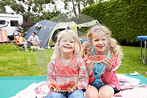 Children Enjoying Picnic Whilst On Family Camping Holiday