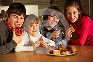 Children Enjoying Plate Of Cakes In Kitchen