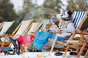 Children enjoys in sun lounger on ski terrain