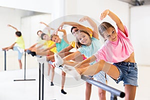 Children exercising ballet moves in studio