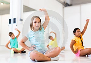 Group of children exercising during yoga class in fitness center - vakrasana pose photo