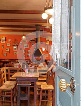 Children (faces not recognisable) sitting in a traditional local tavern through the old door.