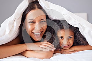 Children, family and bedroom with a girl and mother in bed under a blanket together for love or care in the home. Kids