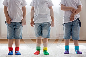 Children feet with different socks standing in rows, kids wearing different socks