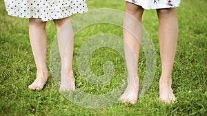 Children feet on green grass