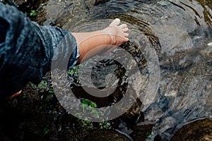 Children feet is touching water creating ripples. Sign of happiness hope and childhood. Boy 2-3 years old