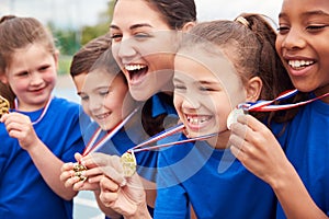 Children With Female Coach Showing Off Winners Medals On Sports Day