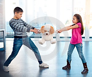 Children, fight or pulling toy in anger, problem or frustrated with youth at home in living room. Young, argument or