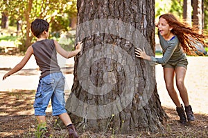Children, forest or playing tag for fun with brother and sister sibling outdoor in nature together. Kids, girl and boy