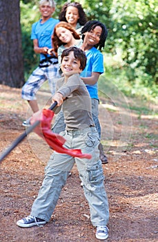 Children, forest and tug of war for play adventure, challenge and strength game in woods with summer camping. Kids