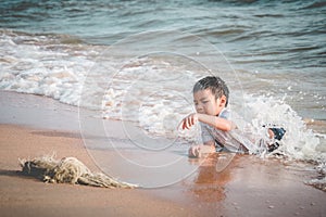 Children found a fishing net on the beach for enviromental clean up concept