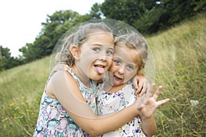 Children friend girls playing whispering on flowers grass in vac