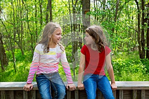 Children friend girls talking on the jungle park forest