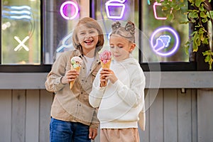 Children friends eating ice cream together while walking in the park