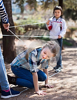 Children games. Girl goes through the tangled rope