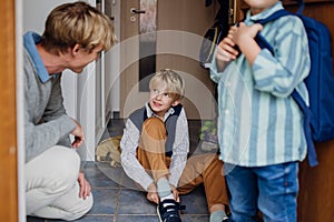 Children getting ready for school, putting on shoes, getting dressed. Father taking them to school and kindergarten