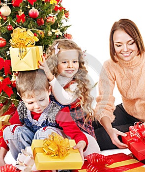 Children with gift box near Christmas tree.