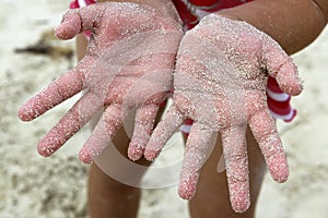 Children girl beach sand hands facing camera