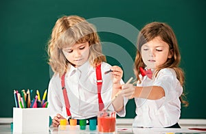 Children girl and boy drawing with coloring pens. Cute school kids painting in class at school. Painting lesson, drawing
