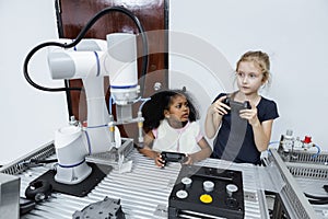 Children girl caucasian using joystick and girl African American control smart robotics arm at class room. electric system skill