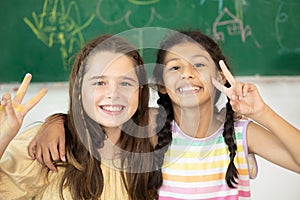 Children girl mix race happy smile in school classroom with chalkboards background