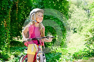 Children girl riding bicycle outdoor in forest