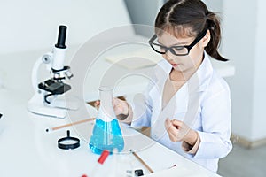 Children girl schoolgirl, Hand holding flask while doing chemistry experiments,