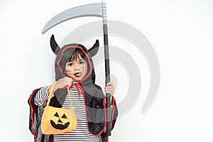 Children girl wearing mysterious Halloween dress holding a scary pumpkin and sickle