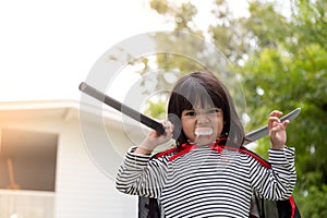 Children girl wearing mysterious Halloween dress holding a sickle on white background