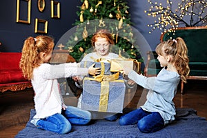 Children give presents to each other for Christmas. Concept of Merry Christmas, vacation and family