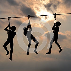 Children gliding on the flying fox contraption against a blue cl