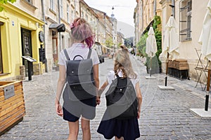 Children going to school, two girls sisters holding hands, back view