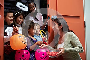 Children Going Trick Or Treating With Mother photo