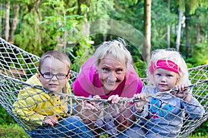 Children with grandmother swinging in a hammock