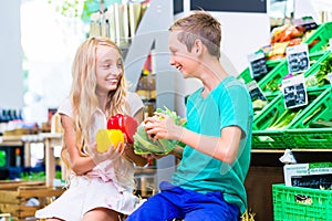 Children grocery shopping in corner shop