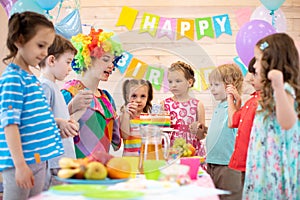 Children group with clown celebrating birthday party