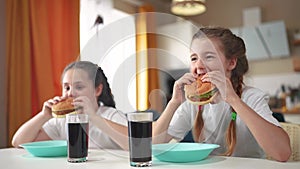 children group eating fast food in the kitchen. delicious breakfast unhealthy food concept. children girls eat