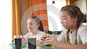 children group eating fast food in the kitchen. delicious breakfast unhealthy food concept. children girls eat lifestyle