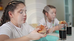 children group eating fast food in the kitchen lifestyle. delicious breakfast unhealthy food concept. children girls eat