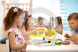 Children group learning arts and crafts in playroom with interest