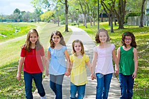 Children group of sisters girls and friends walking in park