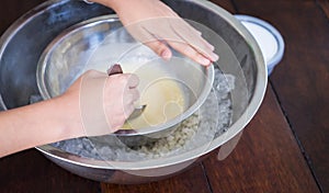 Children hand making home made ice cream with iced bowl.