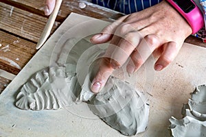 Children hand sculpts clay crafts in pottery school