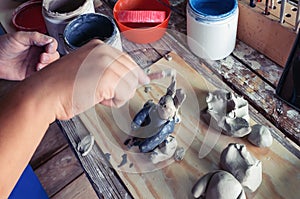 Children hand sculpts clay crafts in pottery school