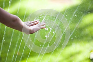 Children hand water drop grass background