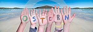 Children Hands Building Word Ostern Means Easter, Ocean Background